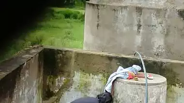 Indian village girl bathing near water tank outdoor